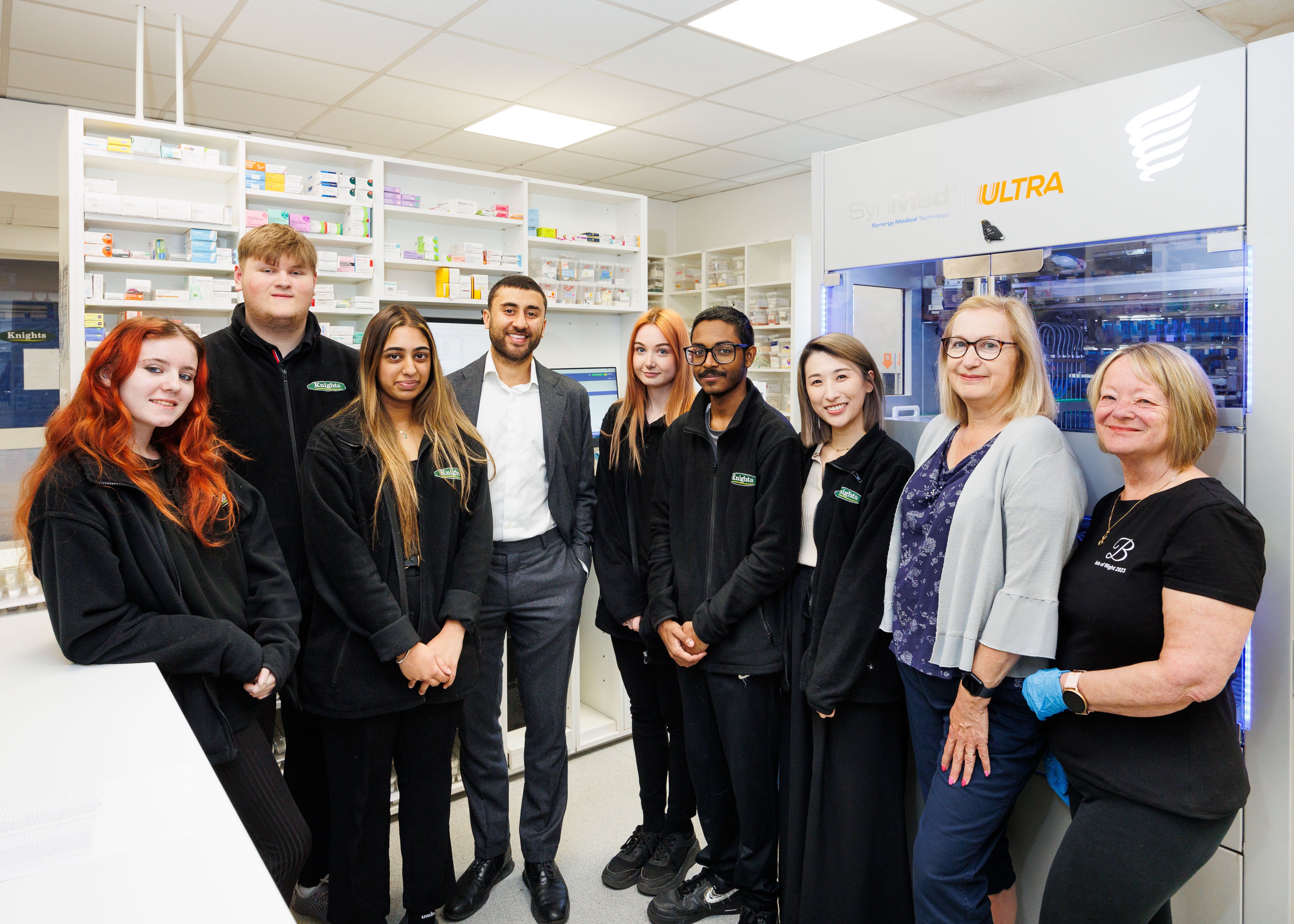 A photo of Anand Sodha (owner of Knights Pharmacy) with the Knights Pharmacy MDS hub team at their HQ in Redditch