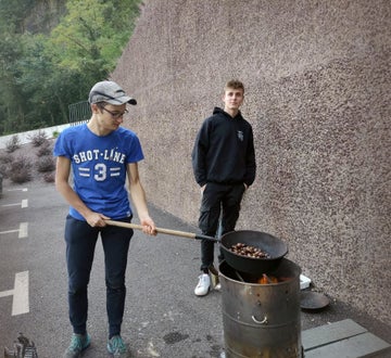 Castagnata: un alunno/cuoco arrostisce le castagne e l'altro...guarda