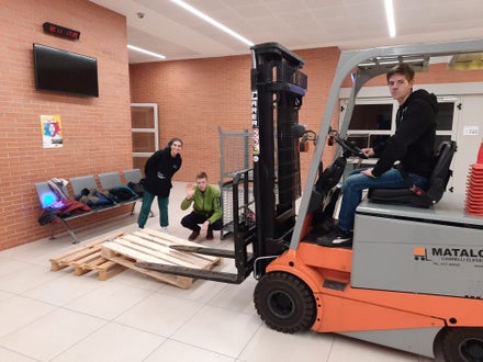 Alcuni corsisti fanno prove per sollevare le assi con il muletto