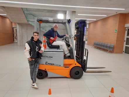 Due corsisti si concedono una pausa appoggiati al muletto