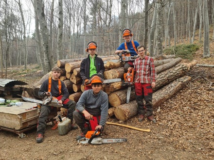 Corso motosega 2022 - foto di gruppo per alcuni alunni di fronte alla catasta degli alberi abbattuti