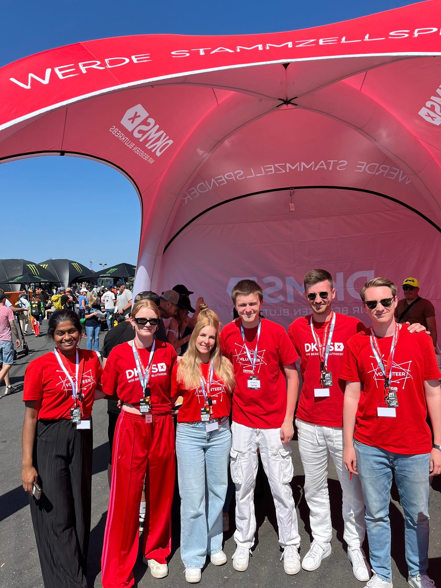 Eine Gruppe von Menschen posiert für ein Foto unter einem Zelt