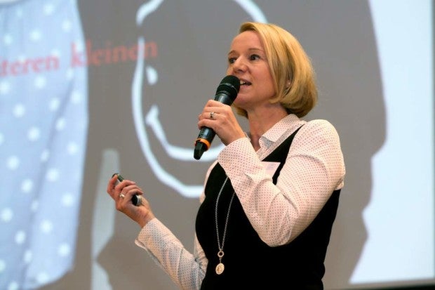 Heike Müller-Jungbluth spricht auf einer Bühne in ein Mikrofon