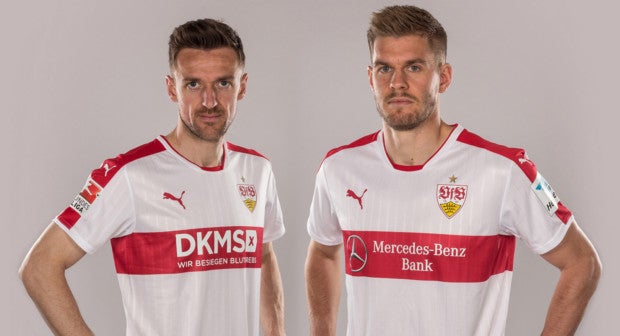 Zwei Fußballspieler des VfB Stuttgart. Der Spieler links trägt ein Trikot mit DKMS Logo