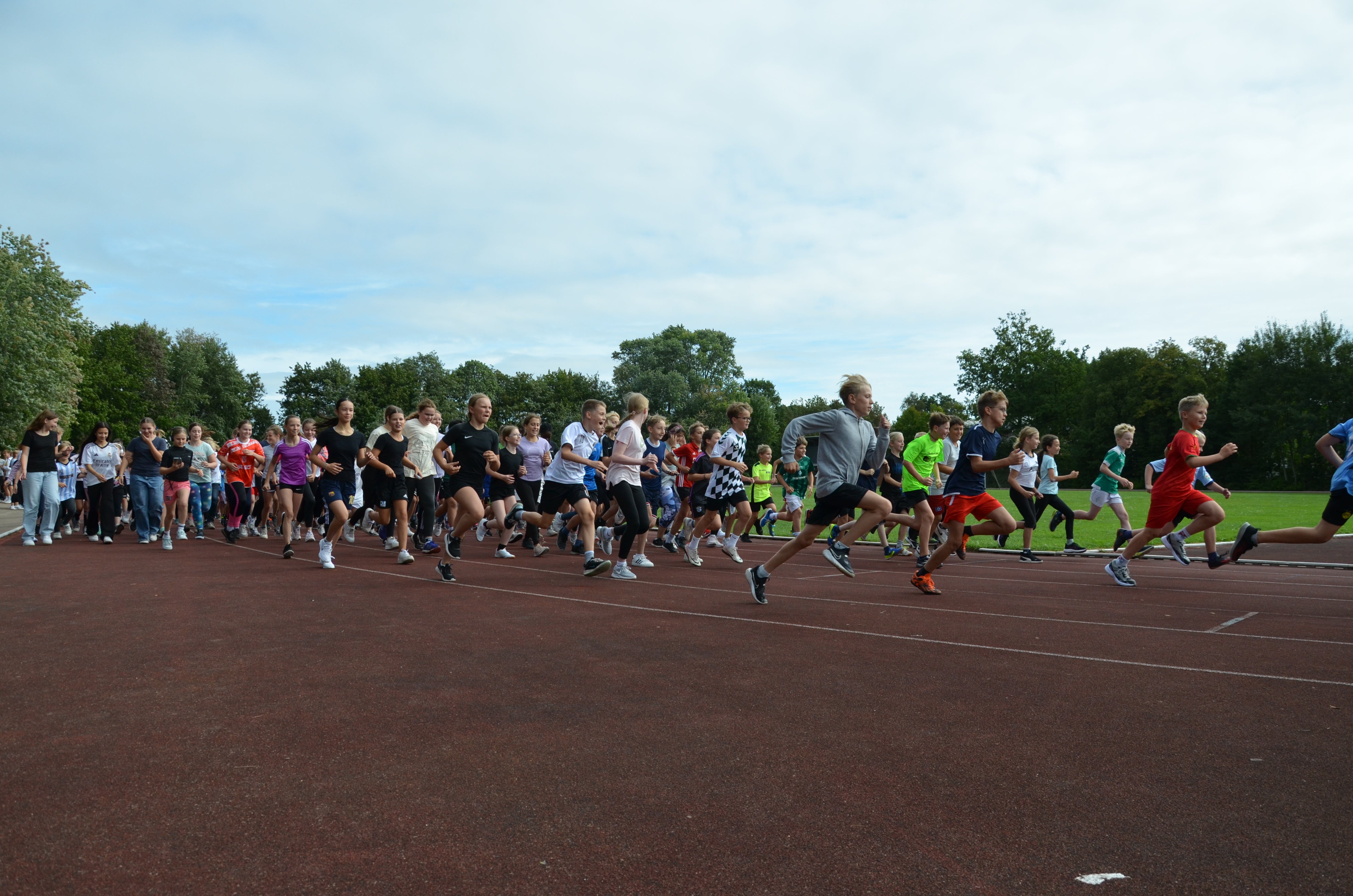 Eine Gruppe von Menschen, die auf einem Tartanlaufbahn stehen