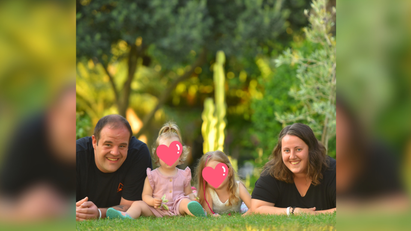 Ein Mann und eine Frau mit zwei Kindern, die auf dem Rasen liegen