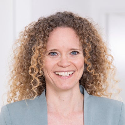 Eine Frau mit lockigem Haar lächelt, Jennifer Andersen