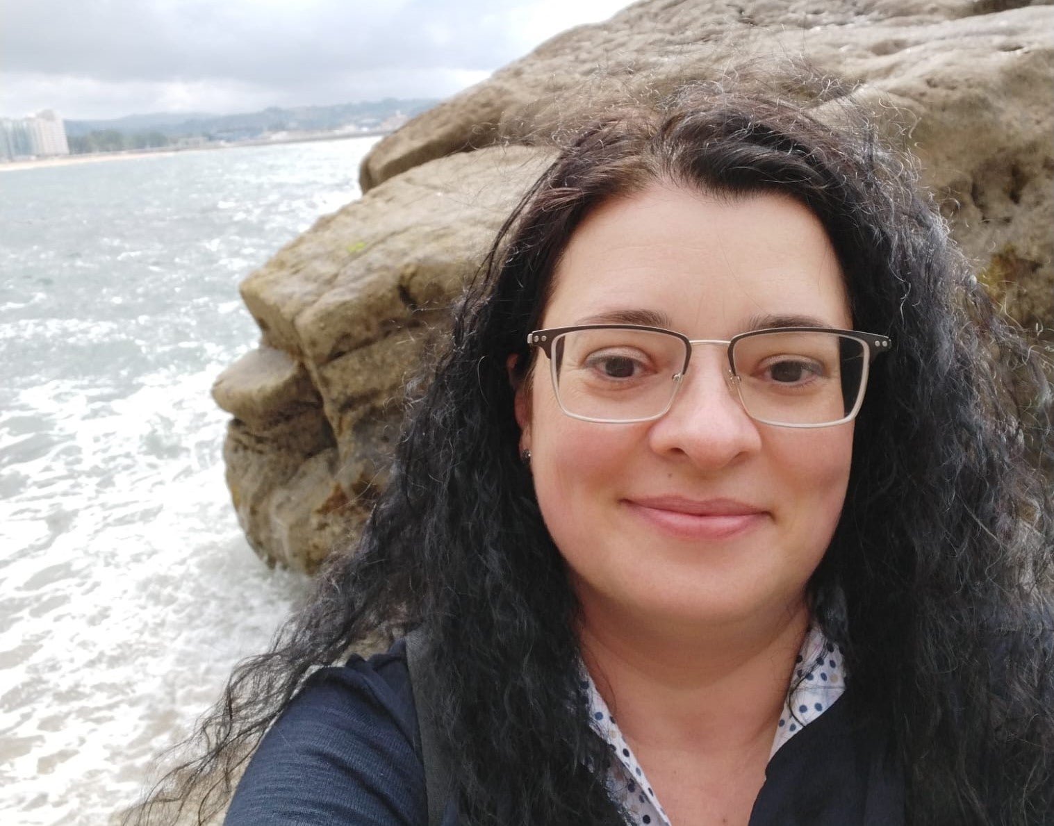 Eine Frau macht ein Selfie am Meer.