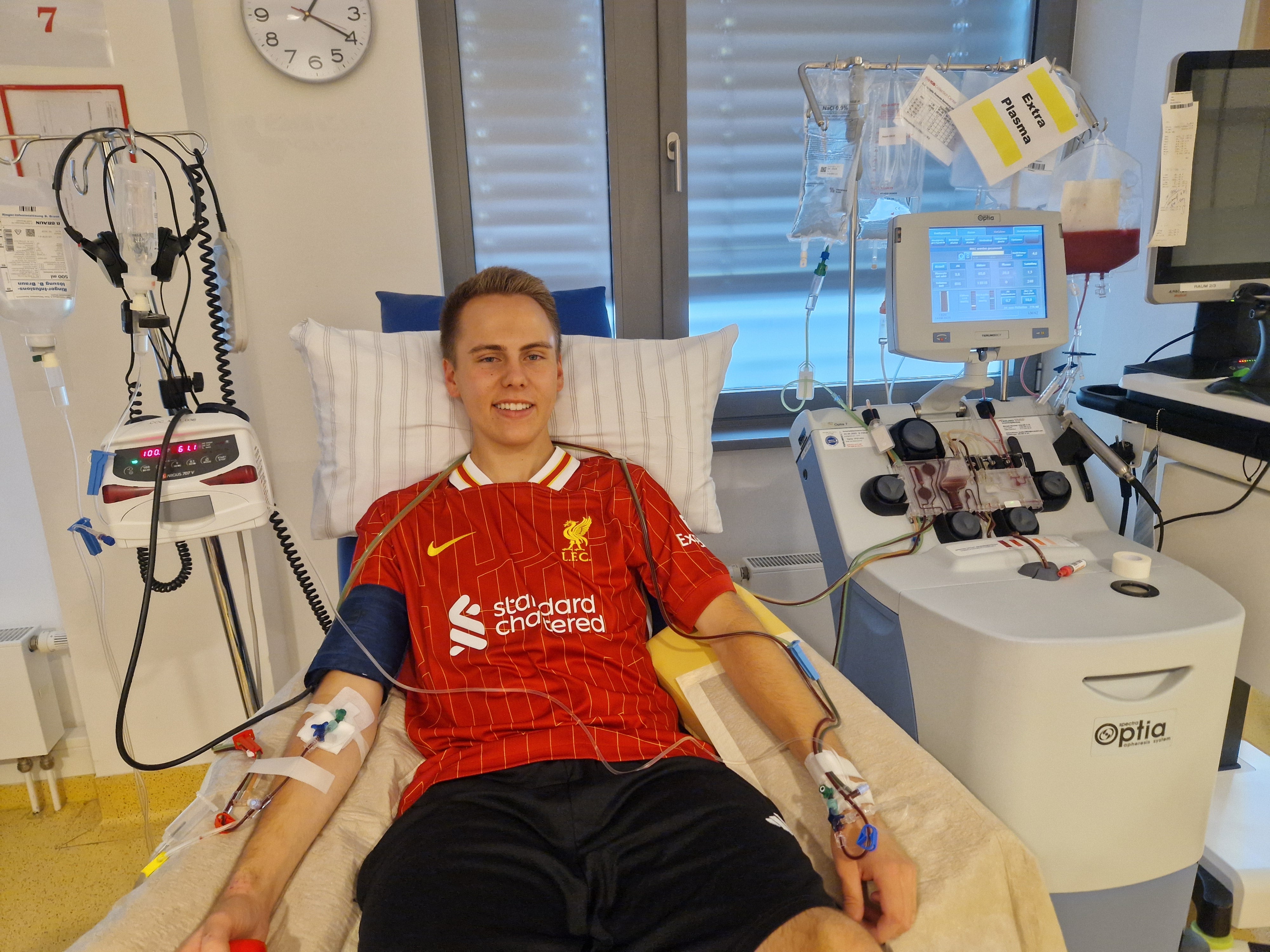 Ein junger Mann sitzt in einem Apheresestuhl für die Stammzellentnahme