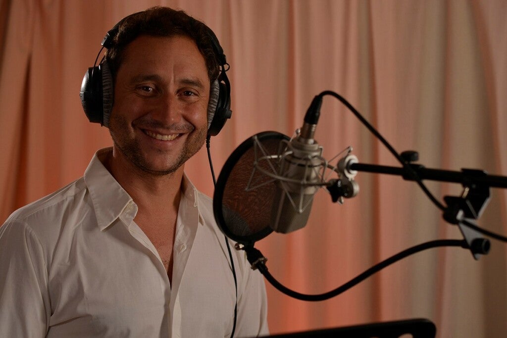 Christian Rex, der Kopfhörer trägt und vor einem Mikrofon steht