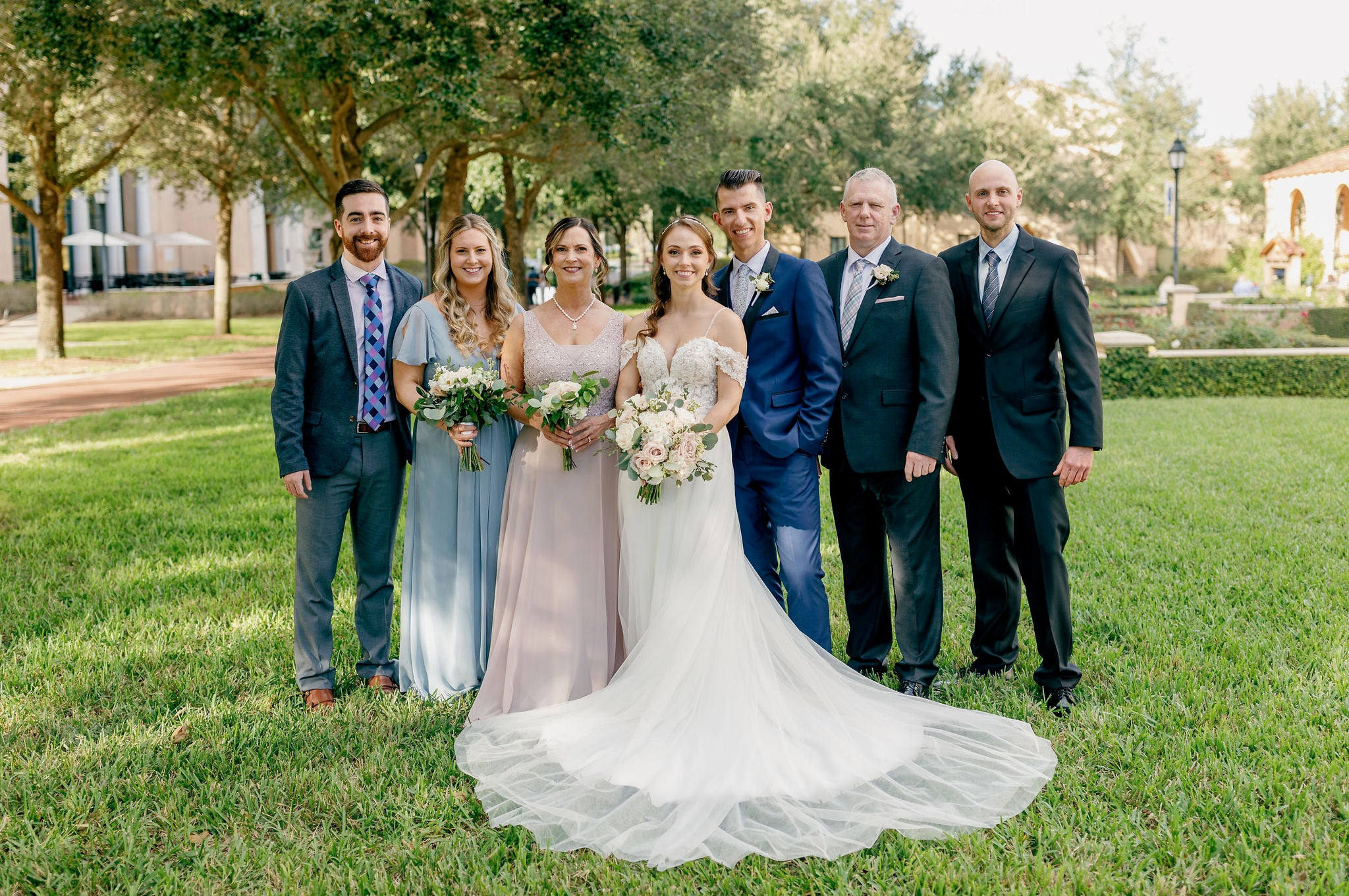 Sieben Personen stehen aufgereiht für ein Hochzeitsfoto