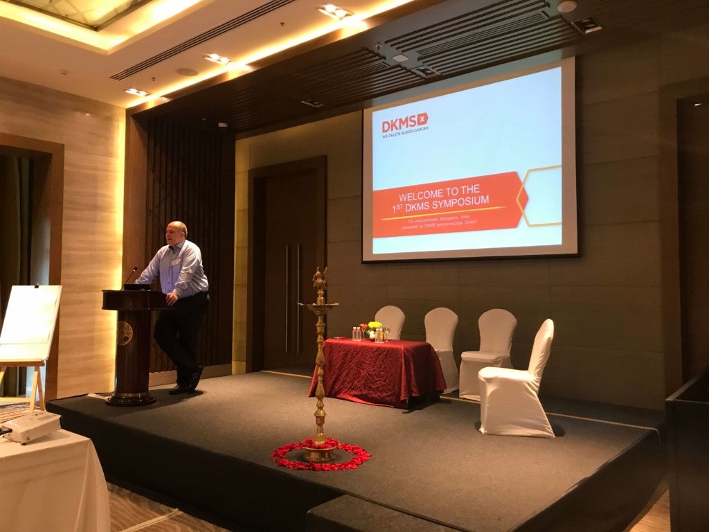 DKMS CMO Dr. Alexander Schmidt bei seiner Begrüßungsrede, im Vordergrund die Öllampe