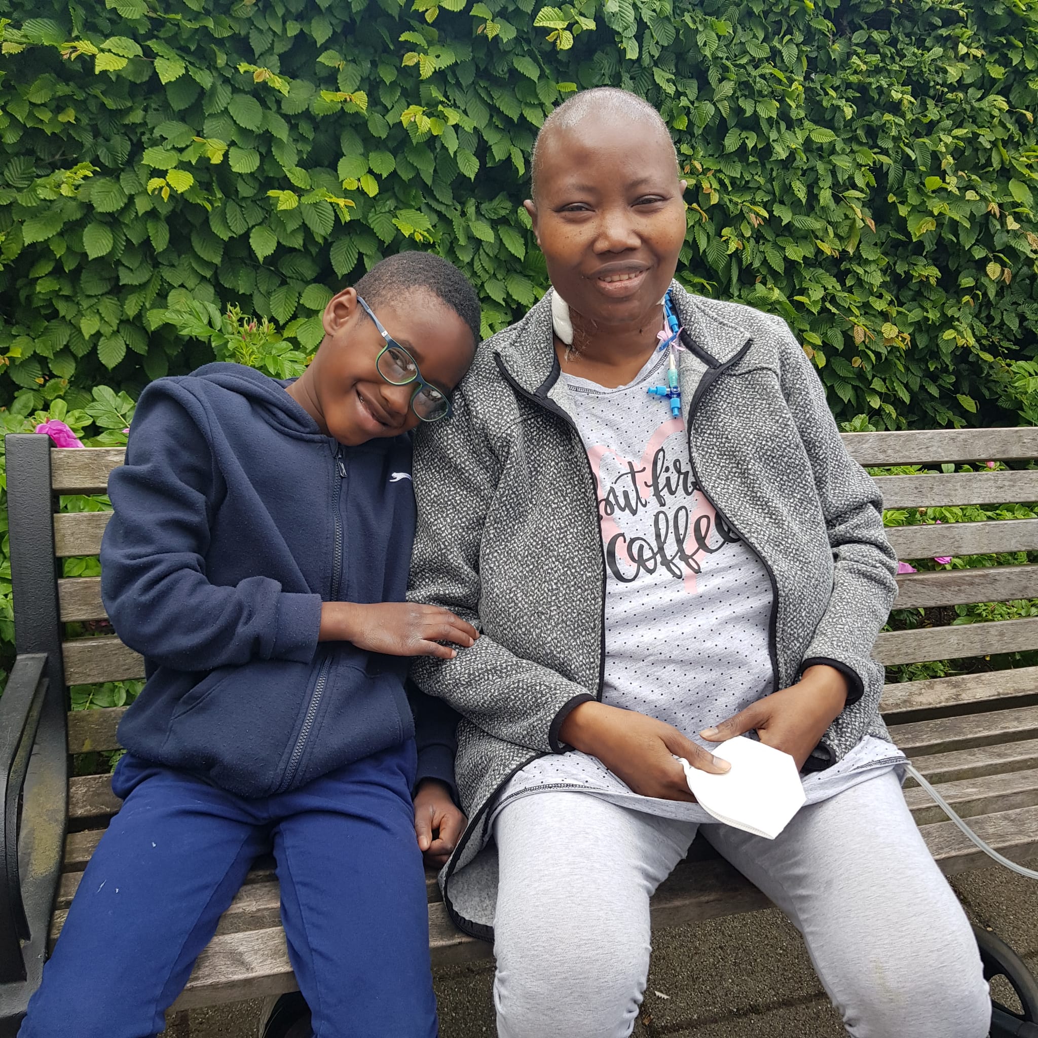 eine Frau sitzt mit einem Kind auf einer Bank