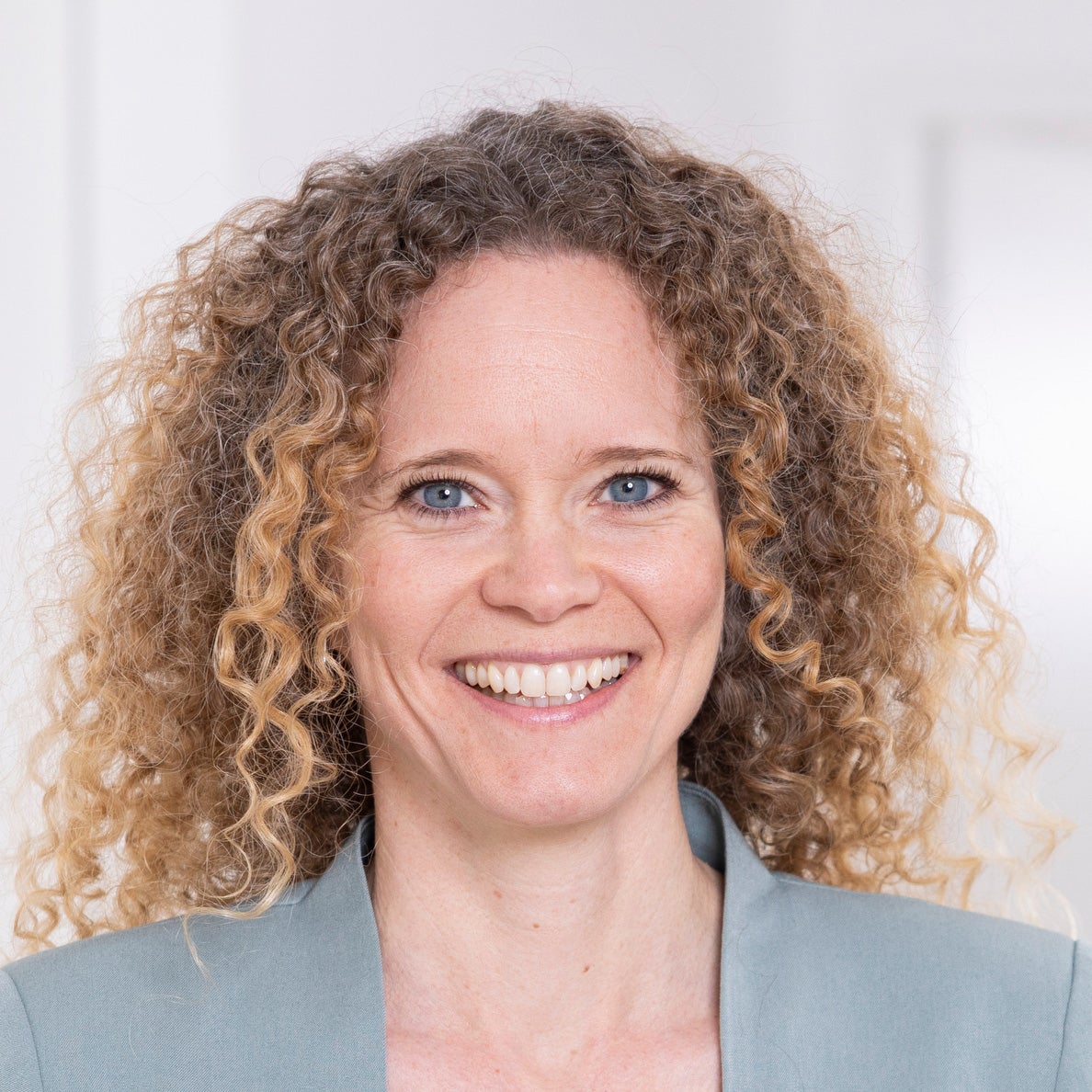 Eine Frau mit lockigem Haar lächelt