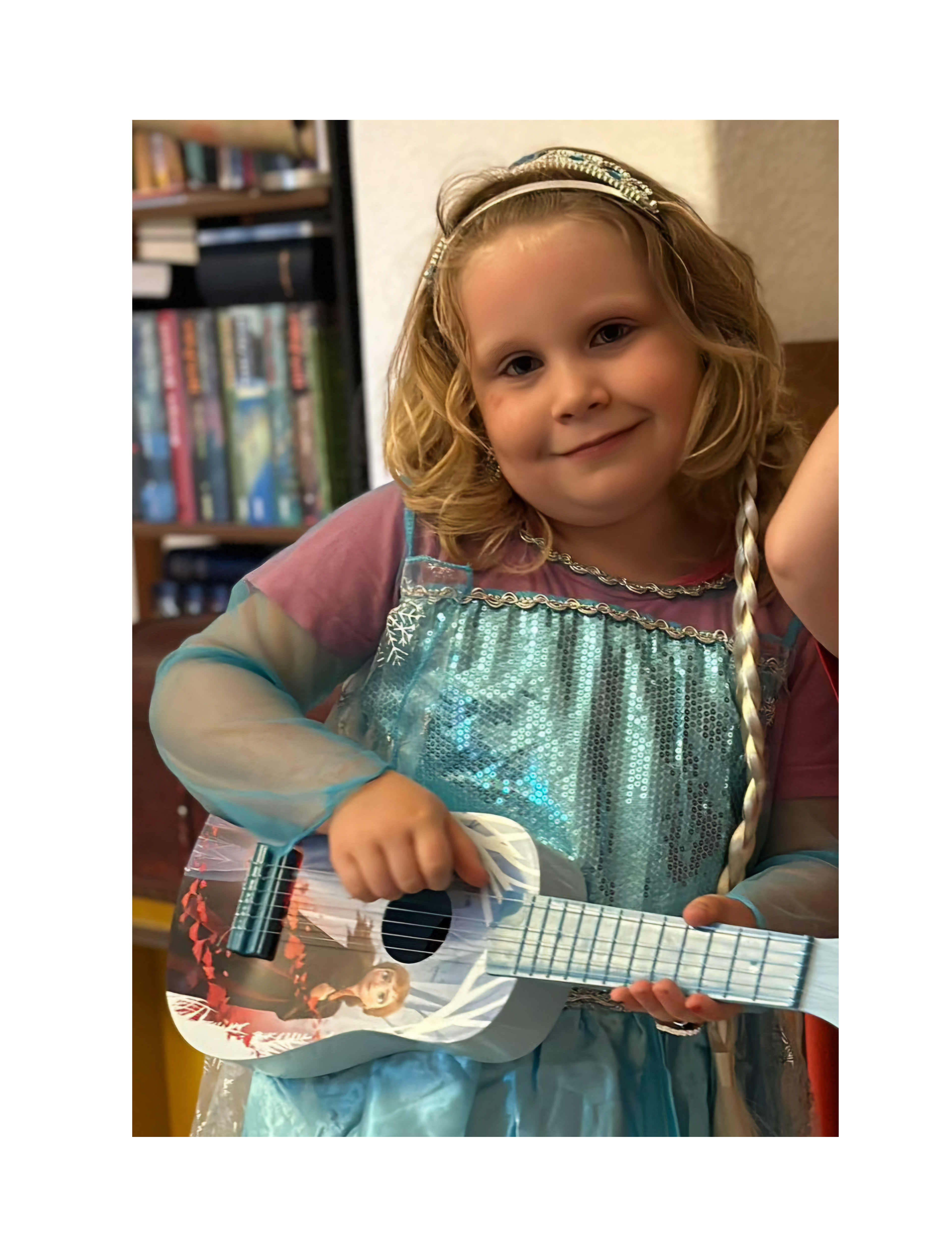 Ein Mädchen hält eine Spielzeuggitarre