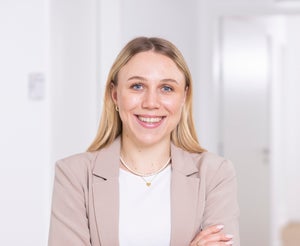 Eine Frau lächelt mit verschränkten Armen