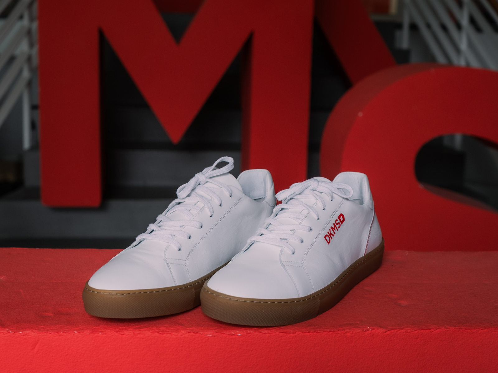 Weiße Sneaker von Imotana mit DKMS-Logo und QR-Code