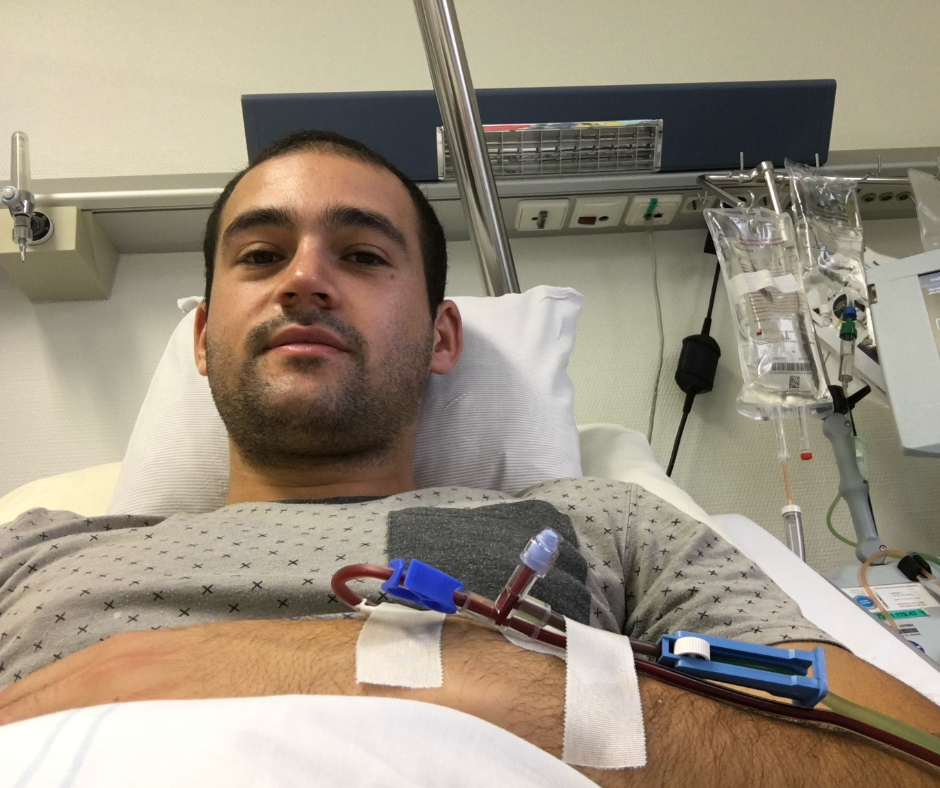 Ein Mann, der in einem Krankenhausbett liegt und an seinem Arm einen Schlauch befestigt hat