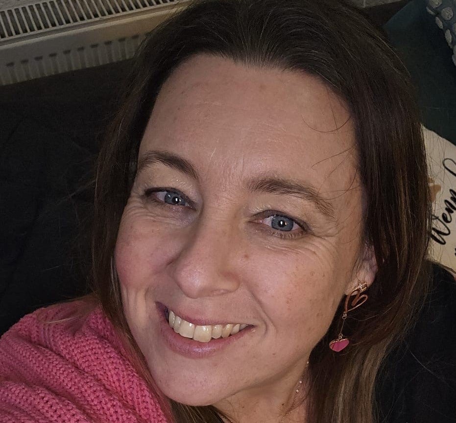 Eine Frau, die in die Kamera lächelt