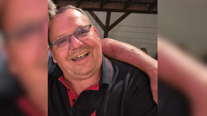Ein Mann lacht und trägt ein schwarzes Polo-Shirt mit der Aufschrift "Feuerwehr Bruchsal".