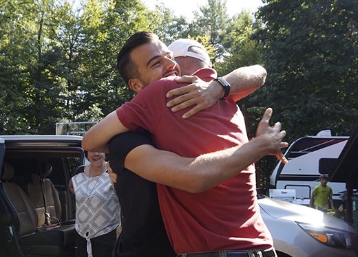 Zwei Männer, die sich draußen umarmen