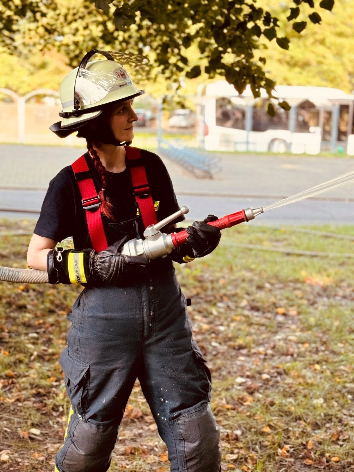 Eine Frau in Feuerwehruniform, die einen Schlauch hält.