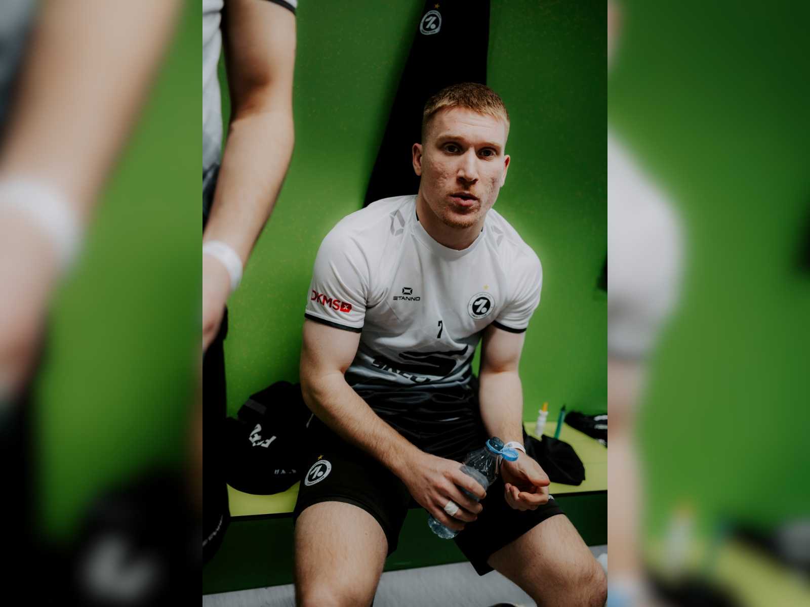 Ein Spieler sitzt auf einer Bank mit einem Wasser in der Hand