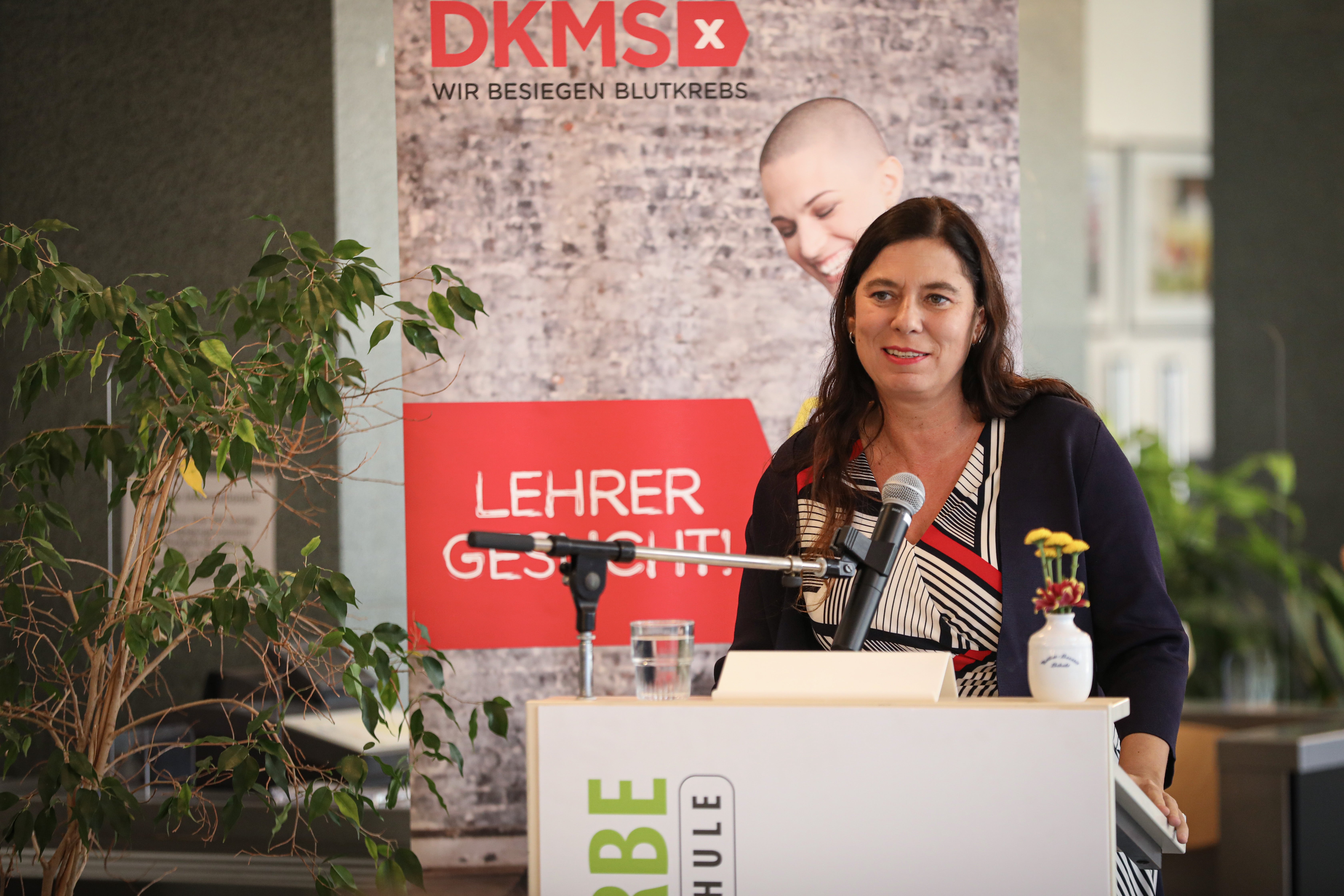 Senatorin Sandra Scheeres steht vor einem Redner:innen Pult