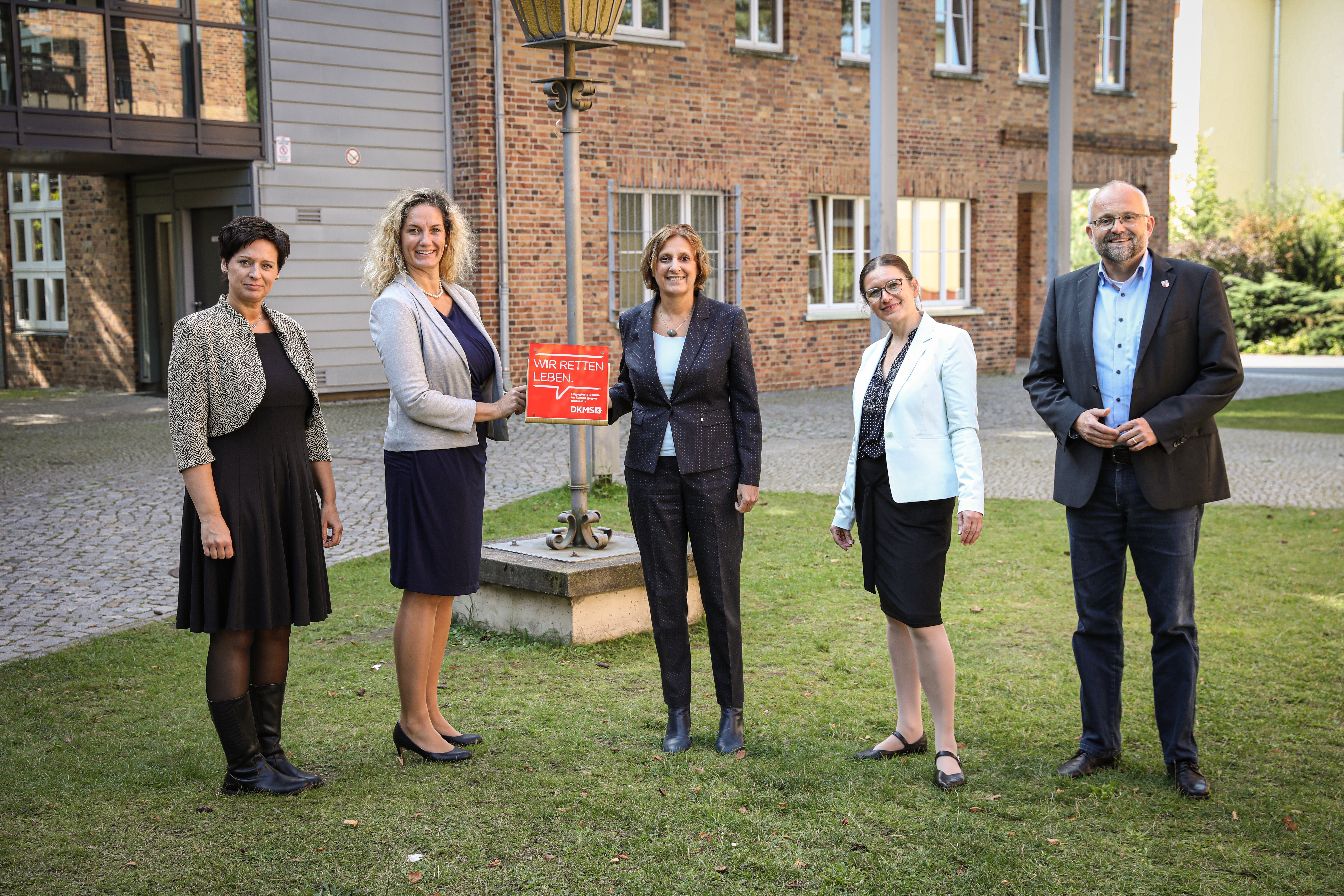 v.l. Bianca Düring und Sabine Prekul (Medizinische Schule), Britta Ernst, Konstanze Burkard, Daniel Kurth (Landrat), sie posieren auf einem Rasen für ein Foto