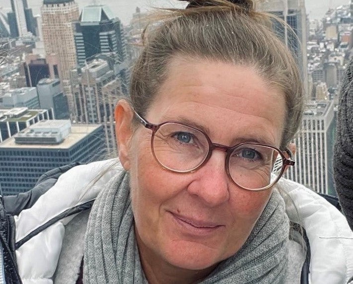 Eine Frau mit Brille lächelt.