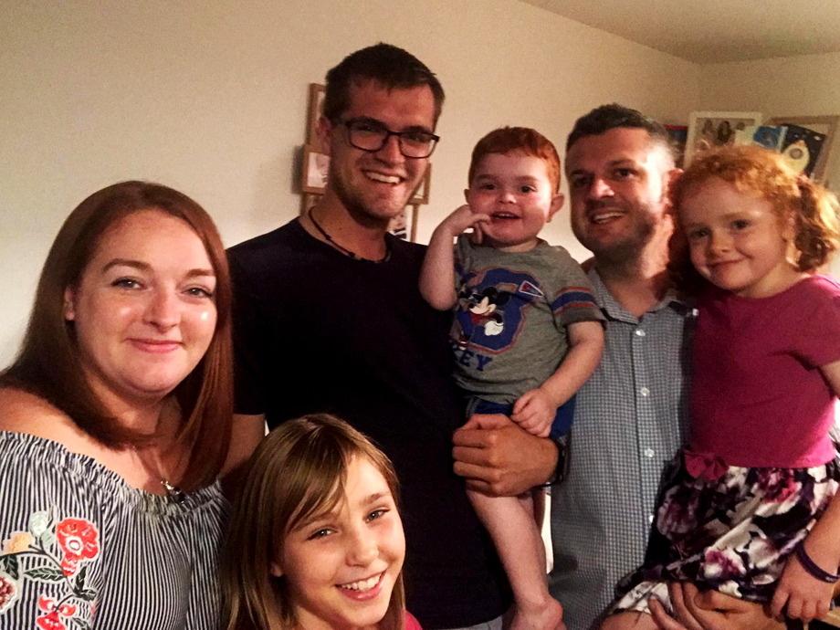 Gruppenfoto mit sechs lachenden Personen, darunter zwei Männer, drei Kinder und eine Frau 