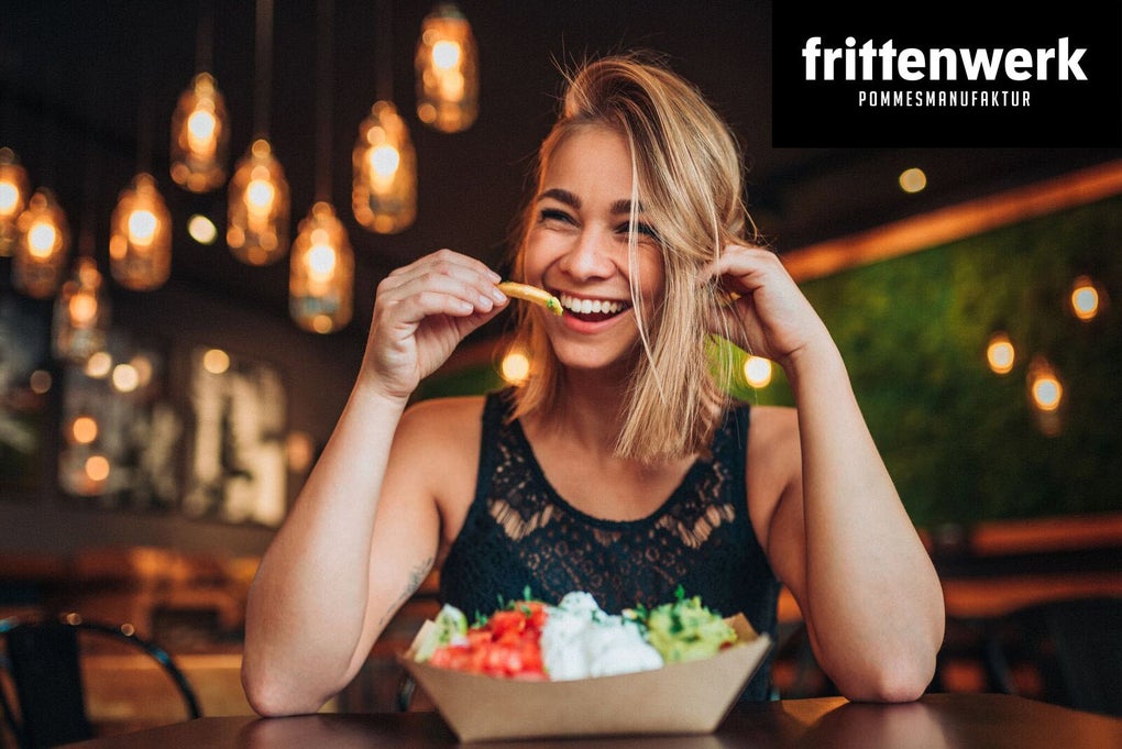 Eine Frau ist 'loaded fries' und lacht in die Kamera