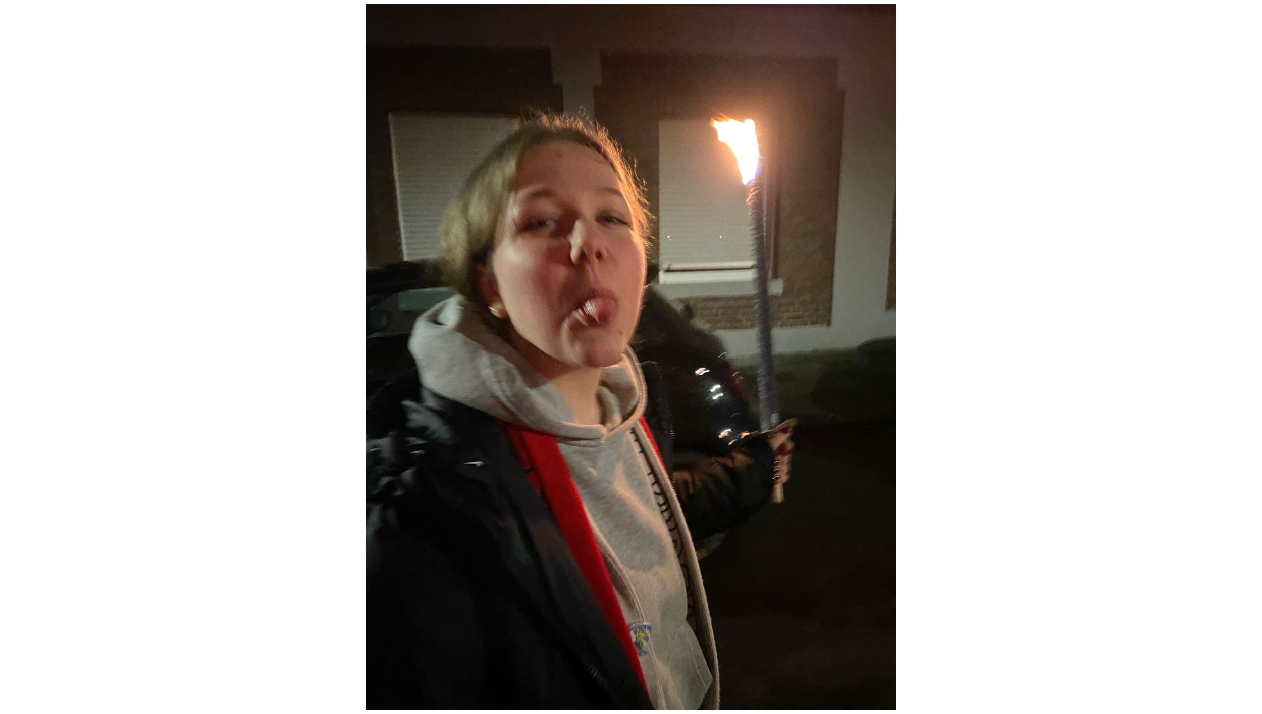 Leonie streckt ihre Zunge heraus und hält eine Fackel in der Hand. 
