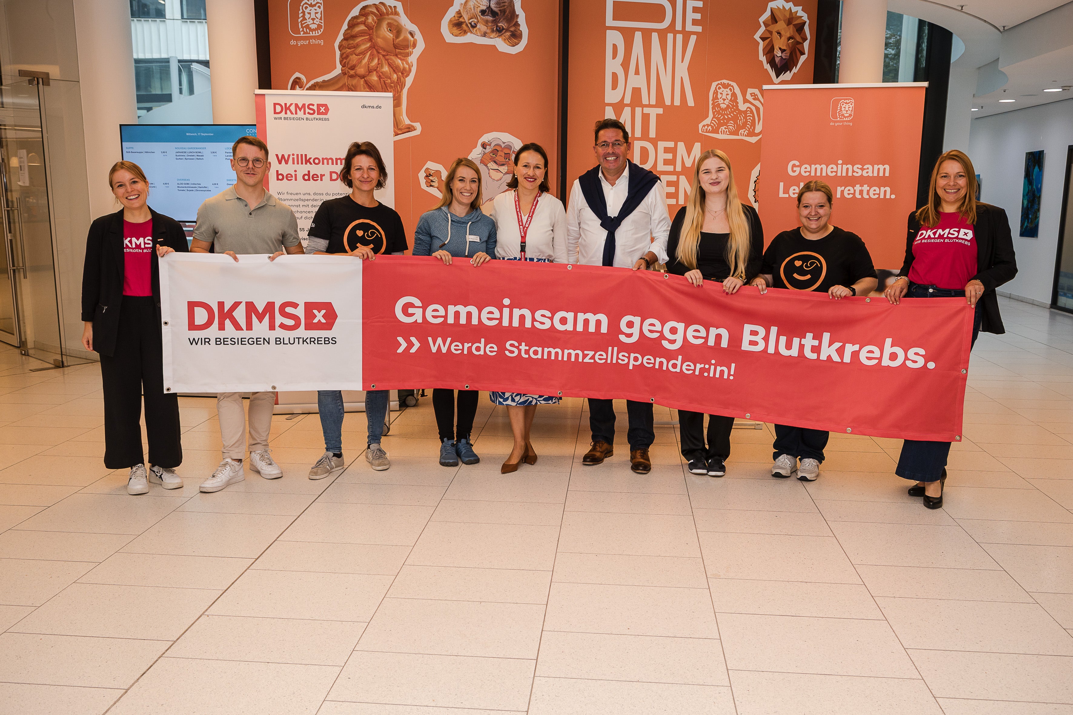 Eine Gruppe von Menschen mit Transparent: "DKMS - Gemeinsam gegen Blutkrebs"