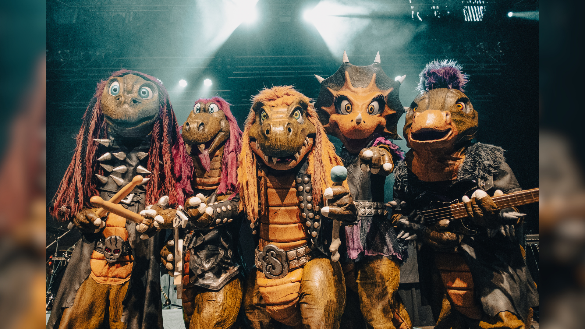 Eine Gruppe von Menschen in Dinosaurierverkleidung mit Instrumenten.