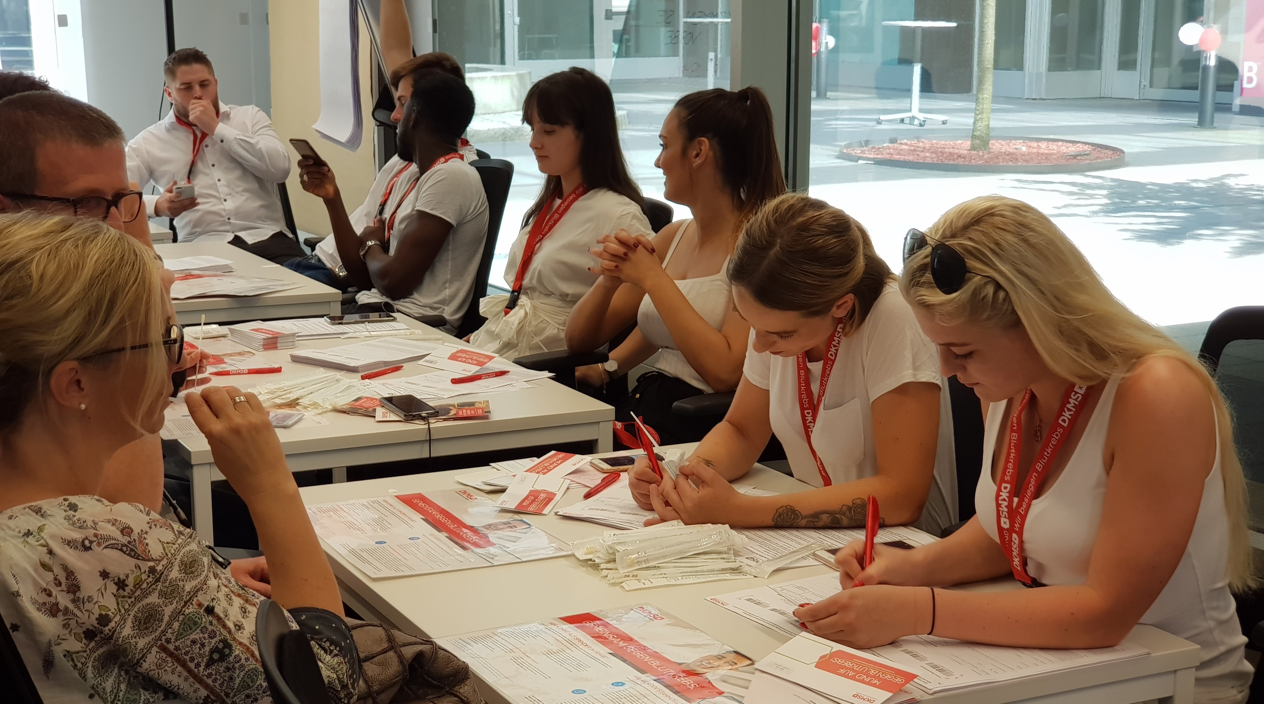 Eine Gruppe von Menschen, die sich gegenüber an Tischen sitzen