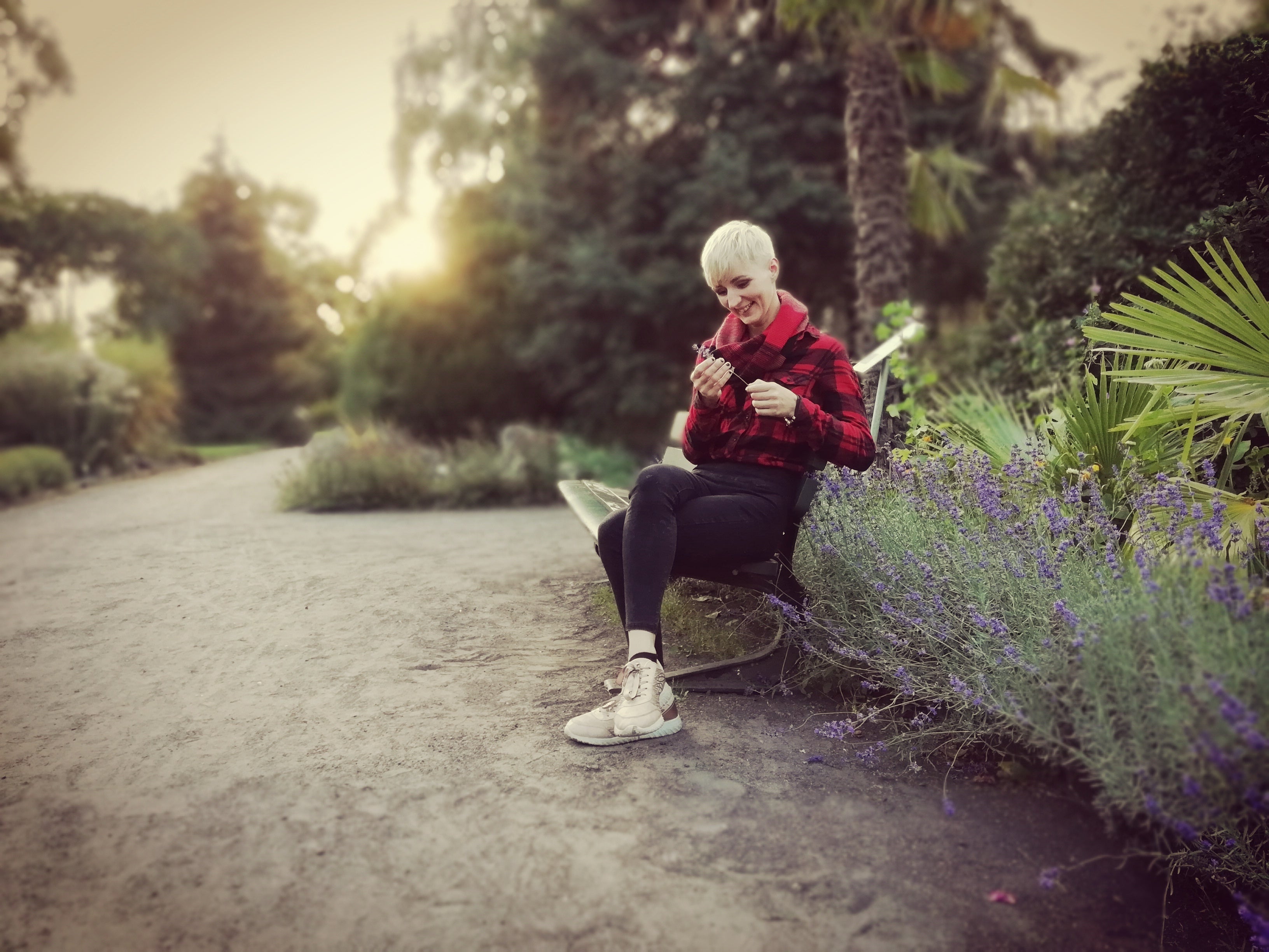 Henrike Oetken sitzt auf einer Bank und hält etwas in der Hand