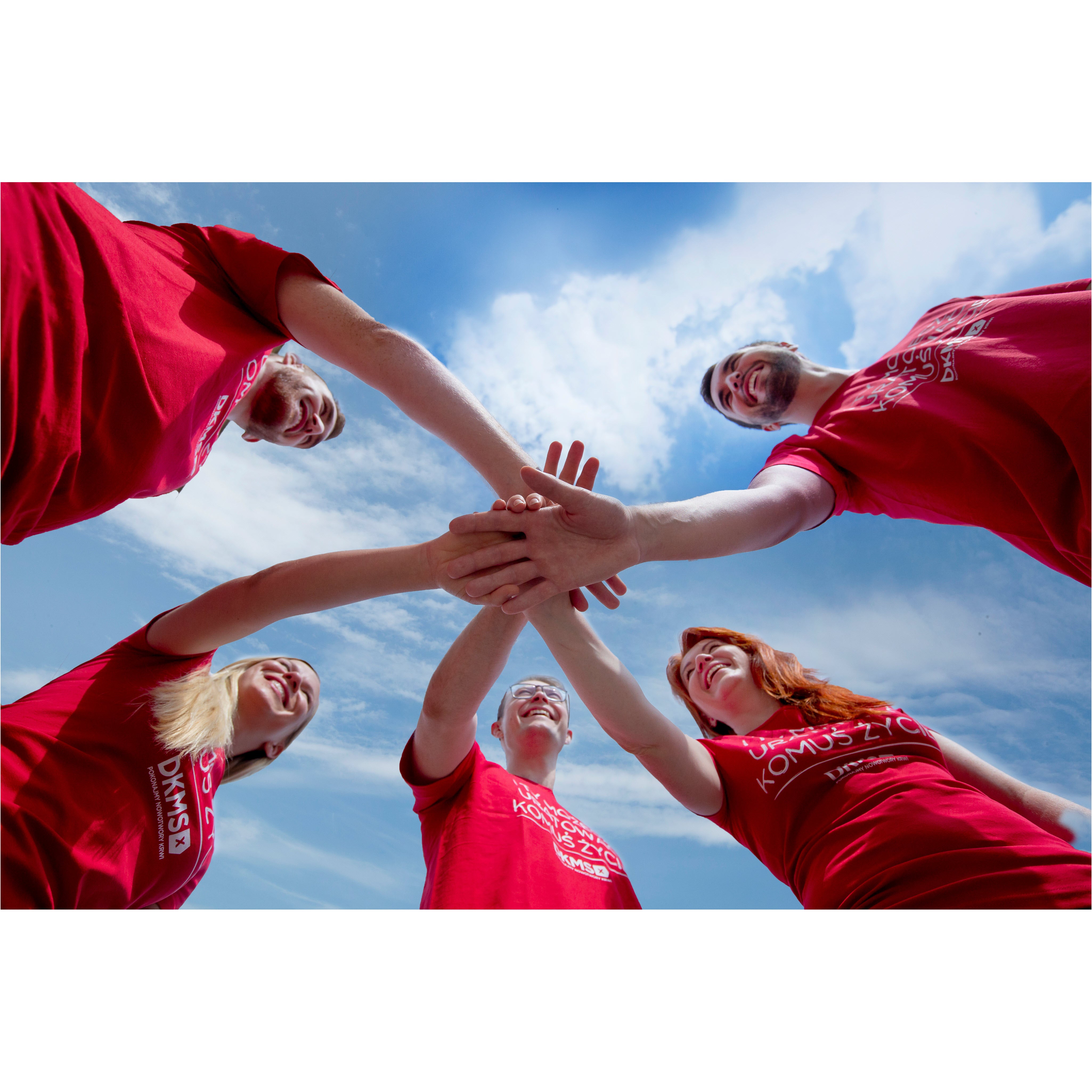 Gruppe von Händen übereinander in einem Kreis.