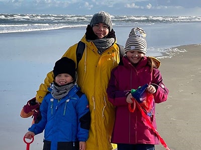 Eine Frau und zwei Kinder an einem Strand