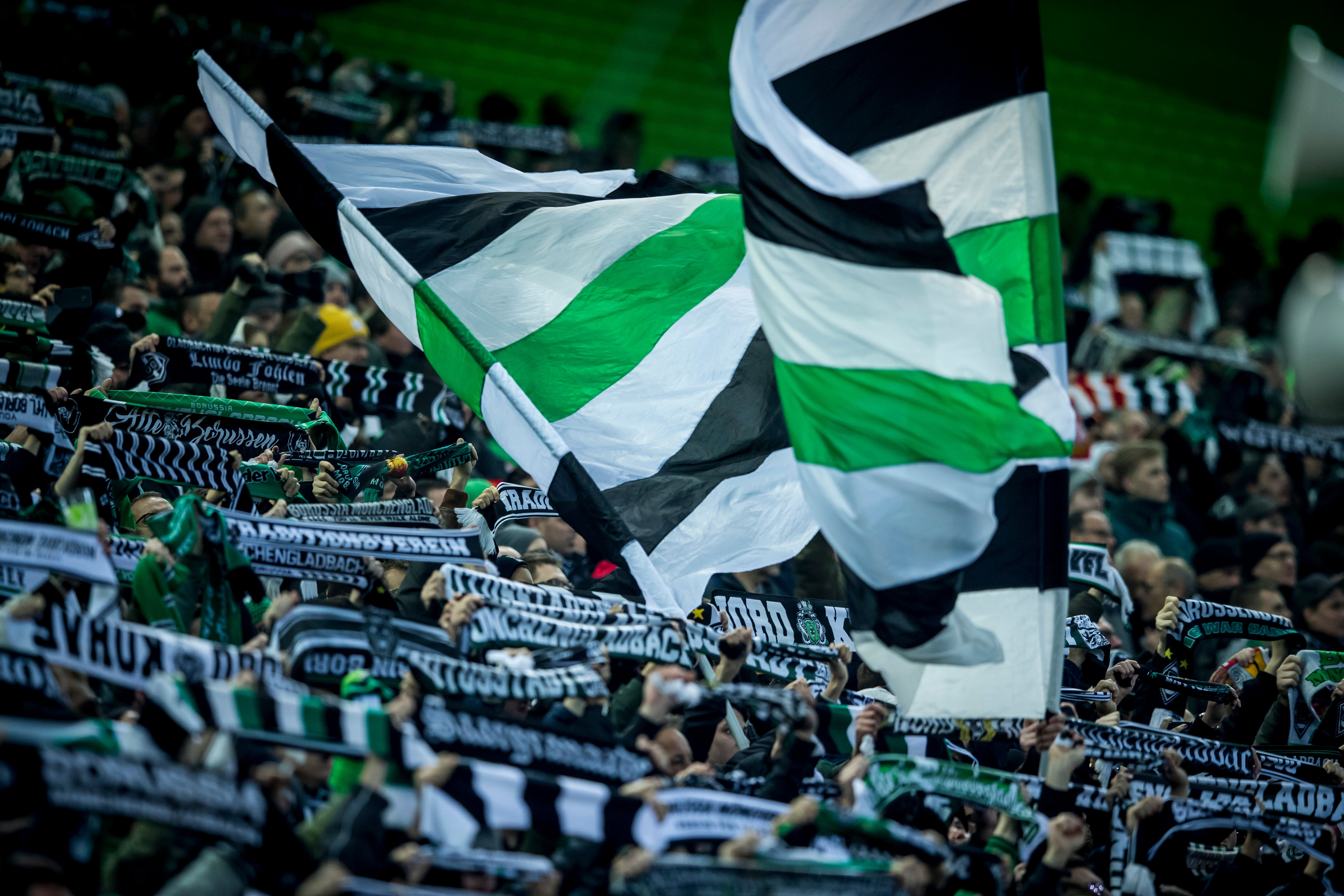 Fankurve im Stadion mit Fahne von Borussia Mönchengladbach.