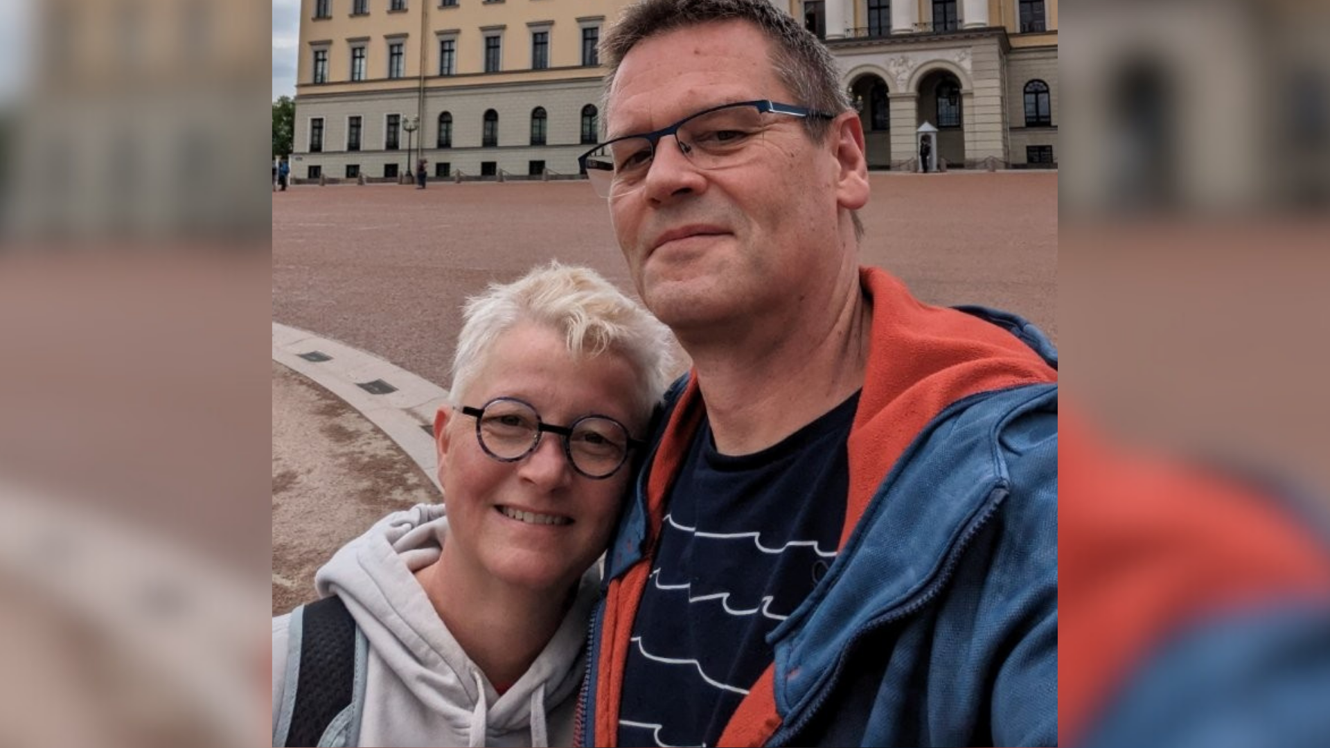 Ein Mann und eine Frau posieren vor einem historischen Gebäude. 