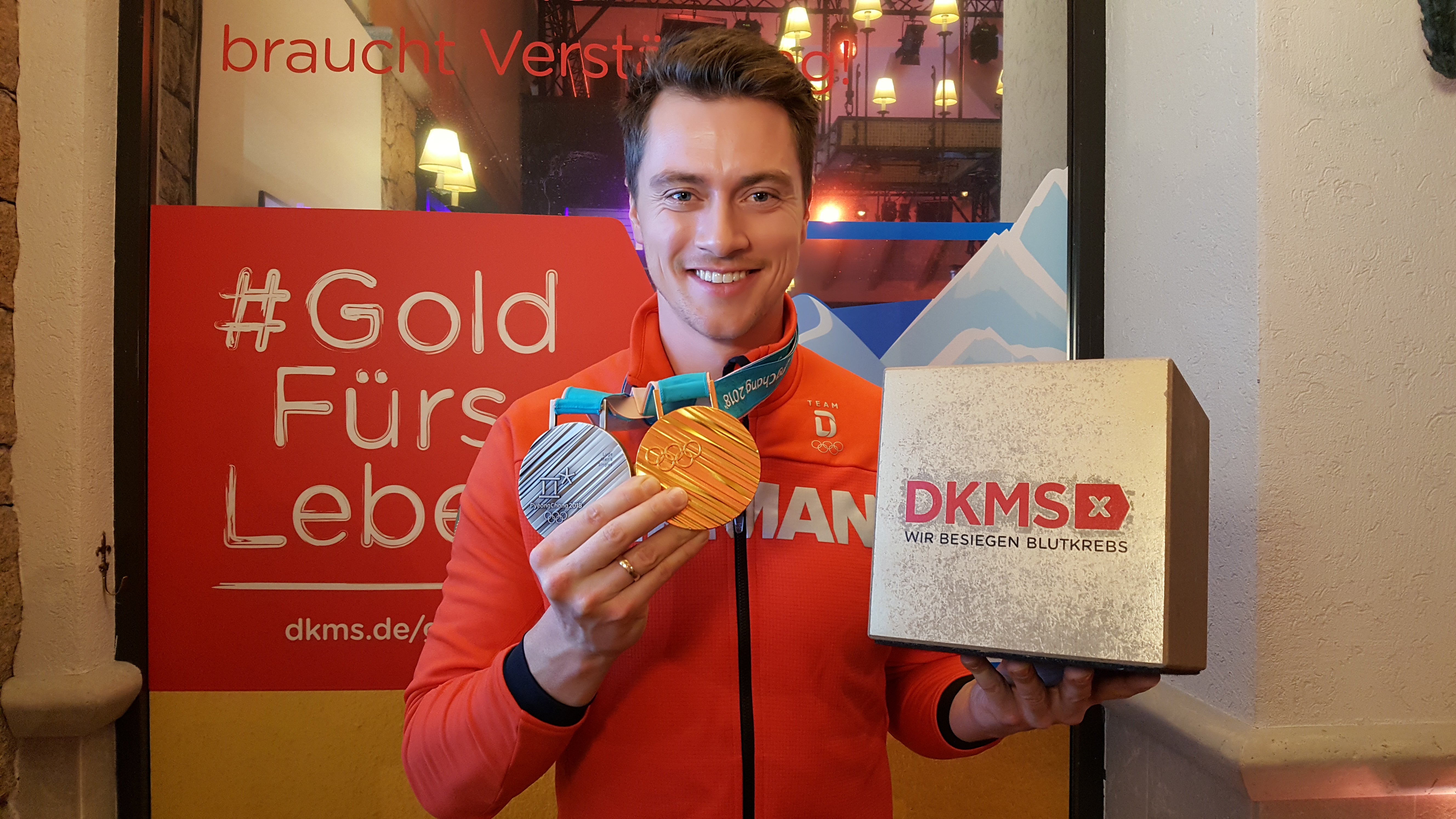 Rodler Johannes Ludwig präsentiert stolz seine beiden Medaillen