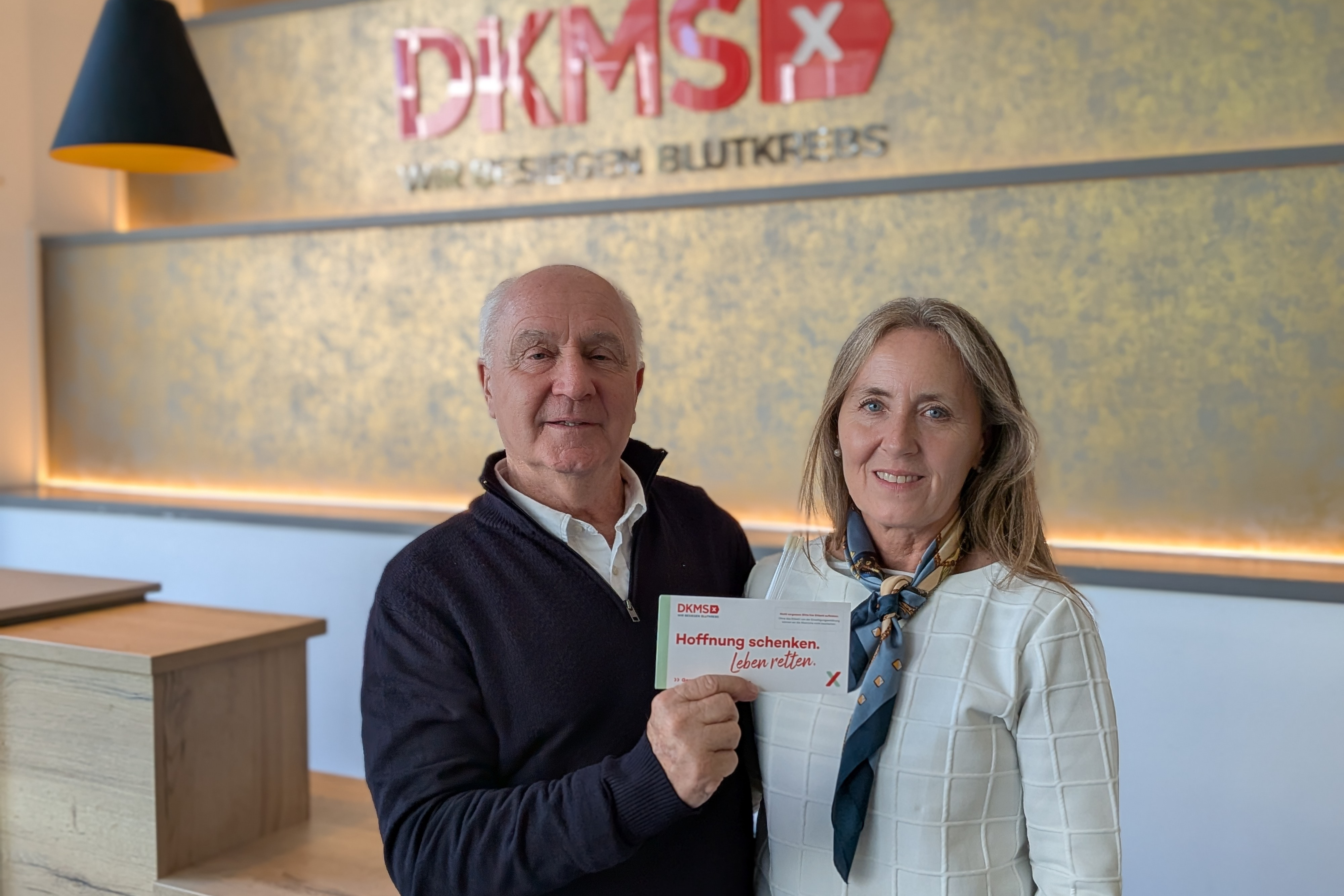 Ein Mann und eine Frau halten eine Urkunde