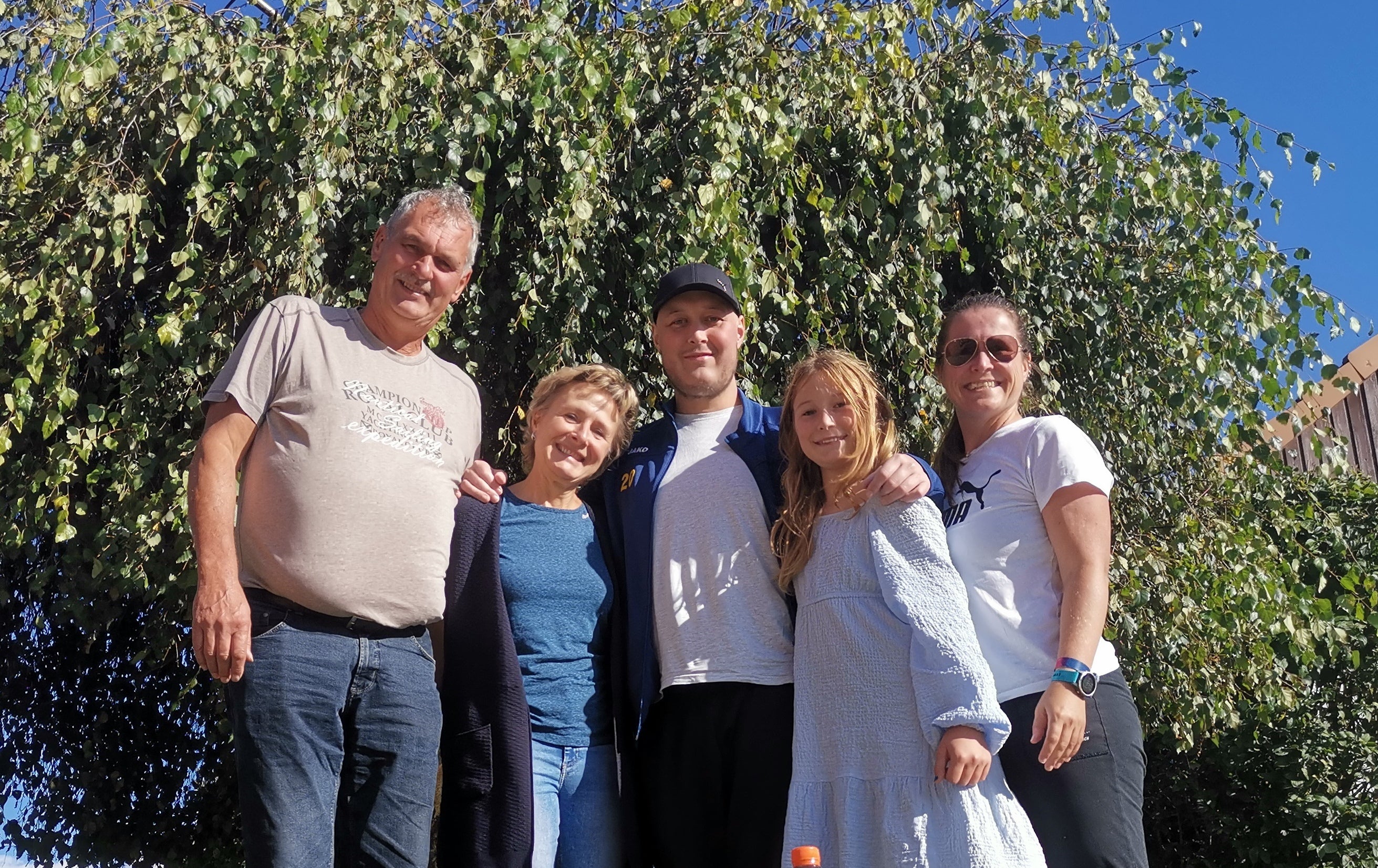 eine Familie posiert vor einem Baum