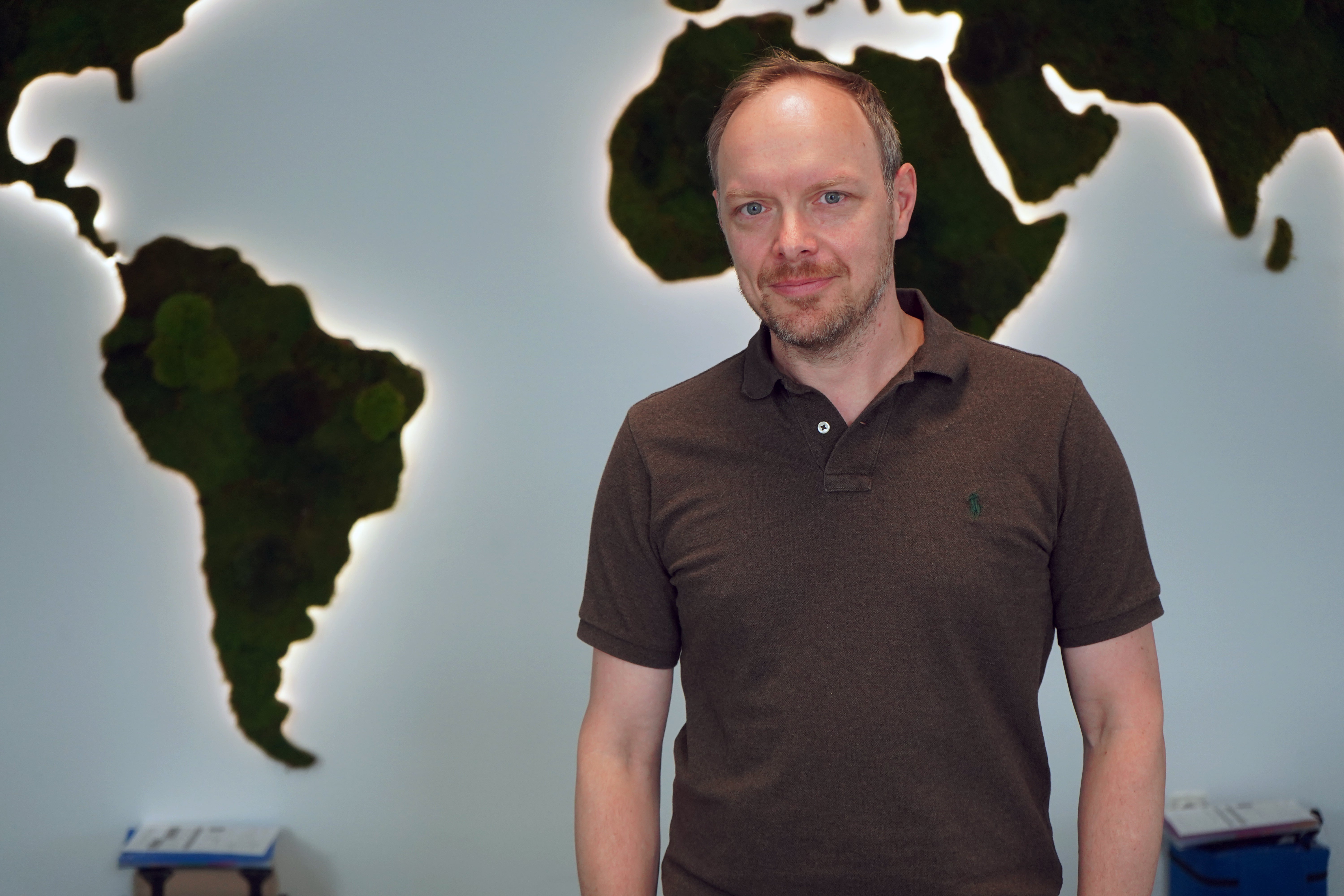 Marco Dehler, time:matters GmbH steht vor einer Weltkarte