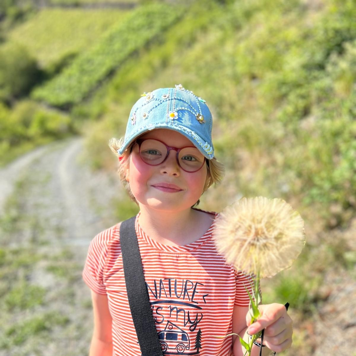 Ein Mädchen hält einen Löwenzahn