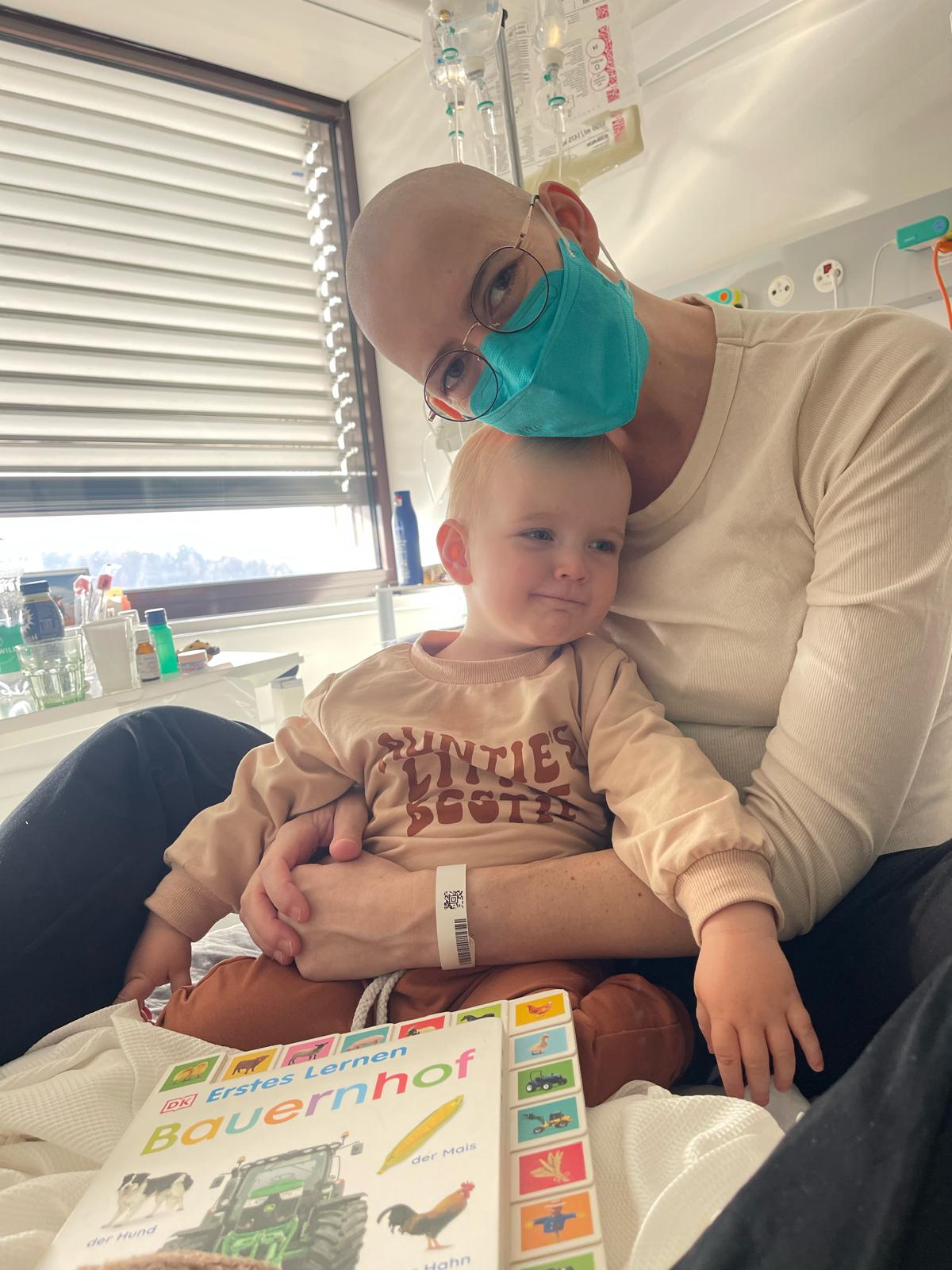 Eine Frau mit einer Maske hält ein Baby