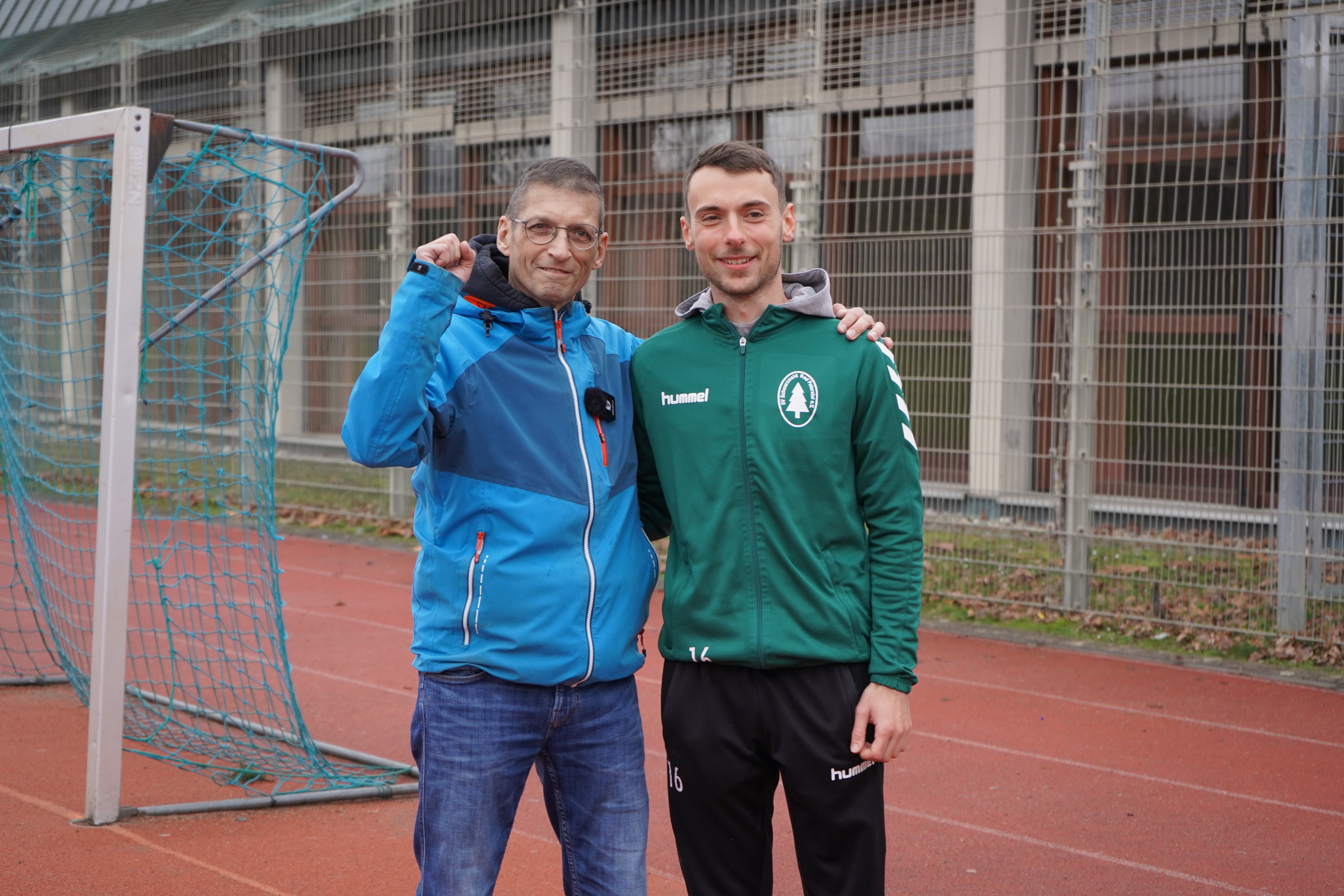 zwei Männer posieren zusammen auf einer Tartanbahn