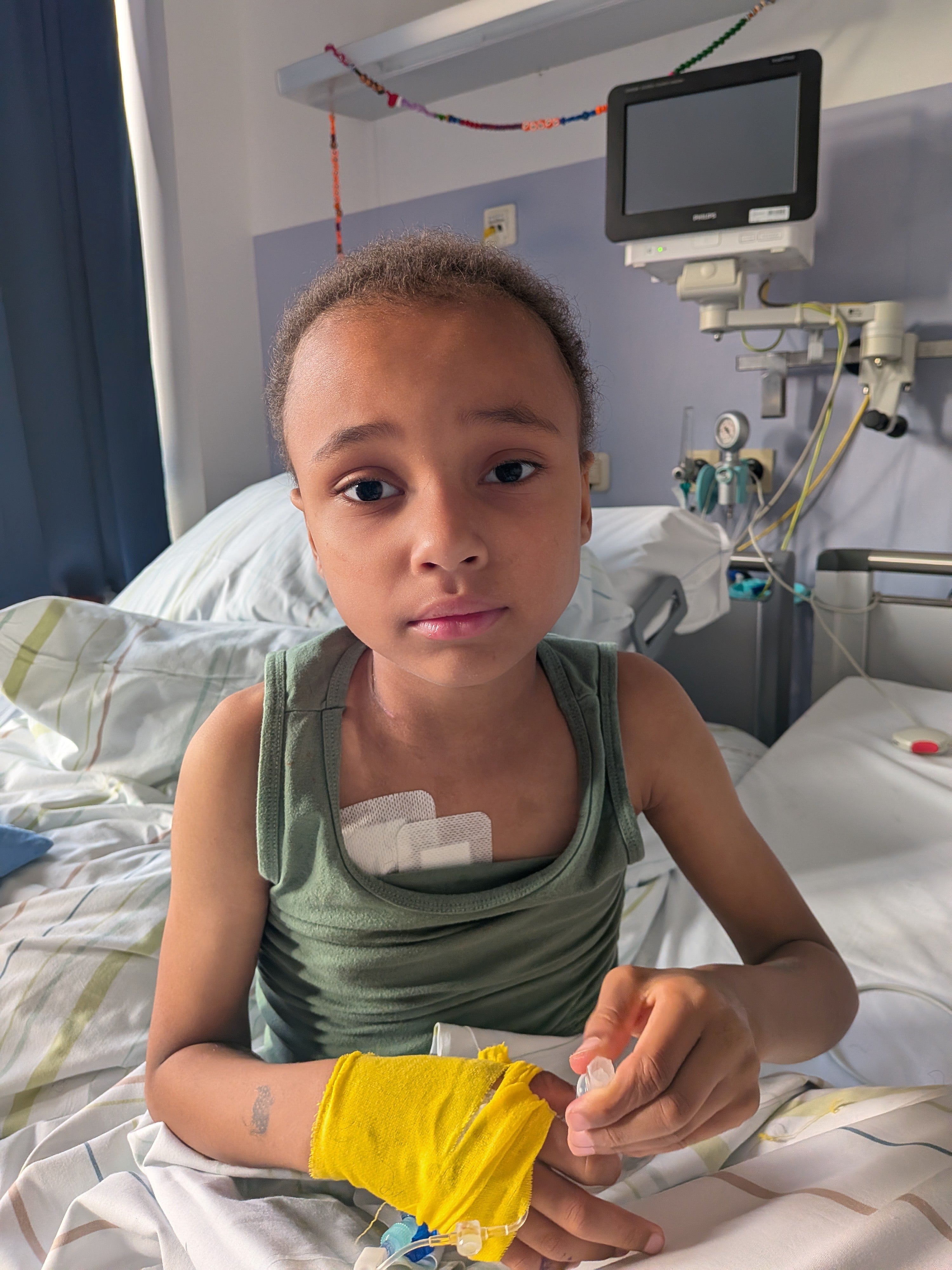 Ein Junge sitzt in einem Krankenhausbett