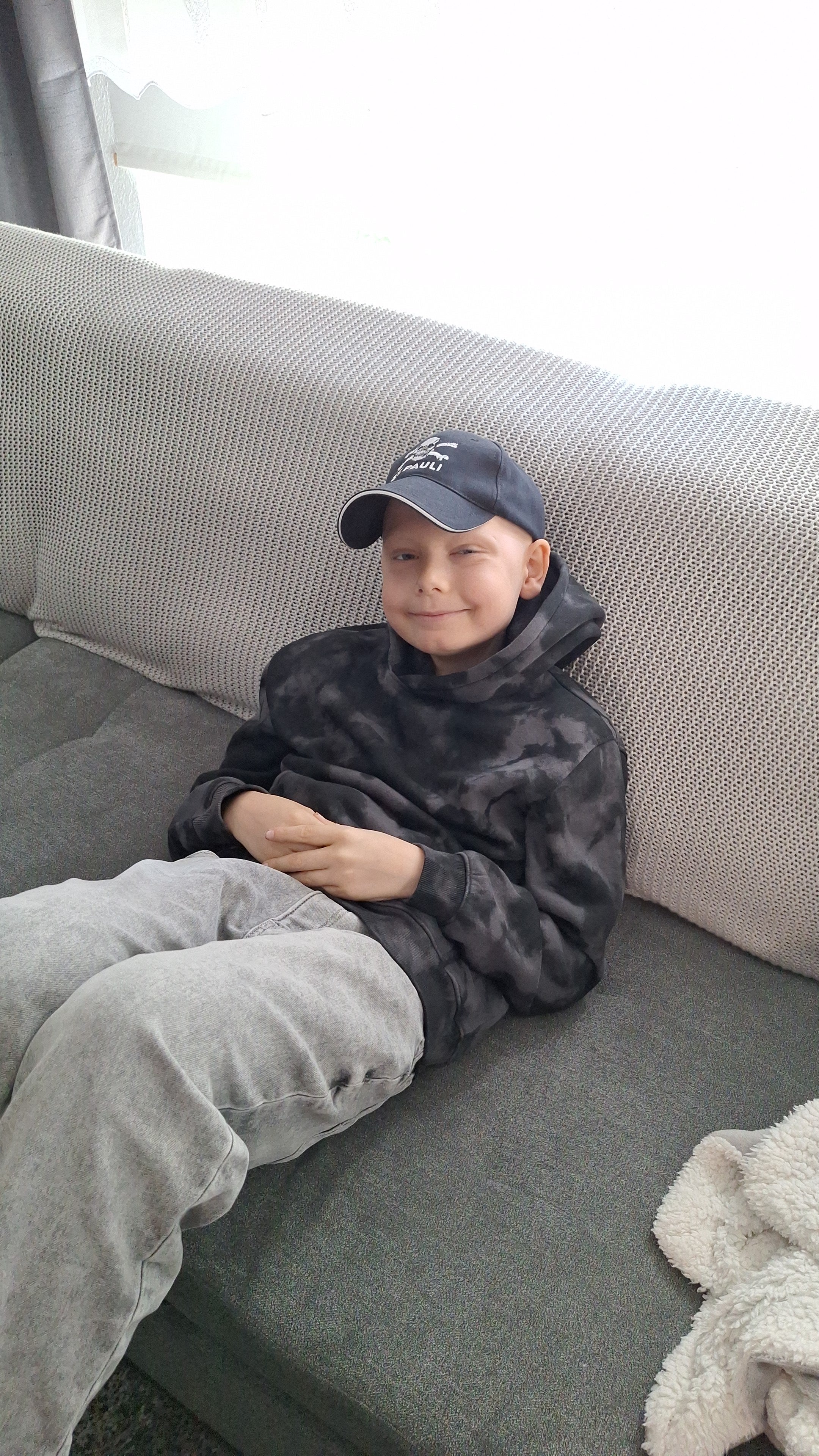 Ein Junge sitzt auf einer Couch